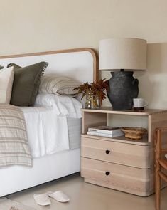 a white bed sitting next to a night stand