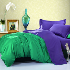 a bed with purple and teal sheets in a bedroom