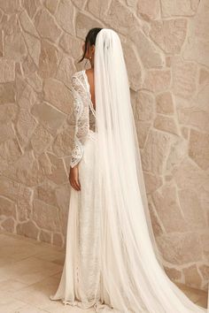 the back of a bride's wedding dress with a long veil