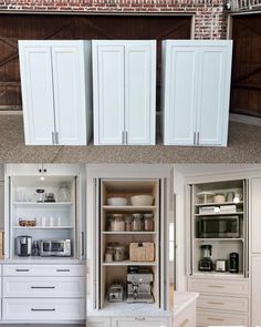 an open cabinet in the middle of a kitchen with lots of cupboards and drawers