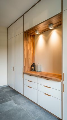 a kitchen with white cabinets and wooden counter tops