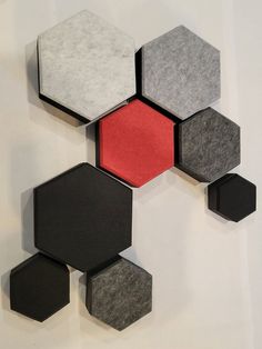 several hexagonal pieces are arranged on the wall, with one red piece in the center