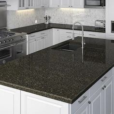 a kitchen with white cabinets and granite counter tops