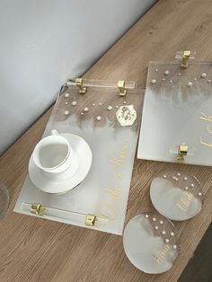 two glass coasters, one with gold lettering and the other with white polka dots