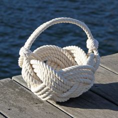 a white rope basket sitting on top of a wooden dock