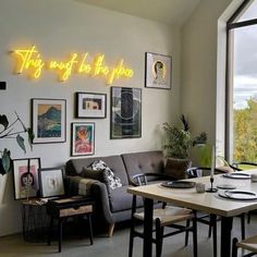 a living room filled with furniture and pictures on the wall next to a large window