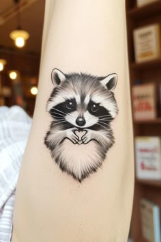 a raccoon tattoo on the arm