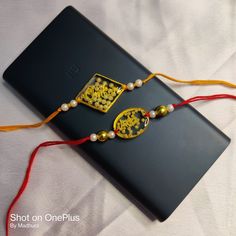 a black book with two gold and white beads on it, sitting on a bed