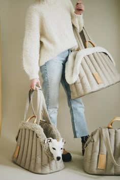 a woman holding two purses and a dog