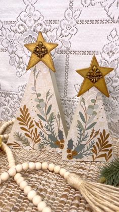 two wooden christmas trees with gold stars on them