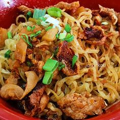 a red bowl filled with noodles and meat