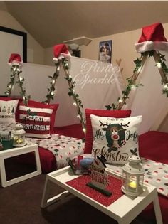 christmas decorations are on display in the corner of a room with red and white bedspreads