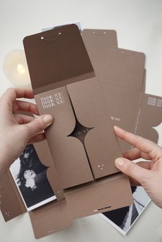 two hands holding several pieces of cardboard with pictures on it and one person's hand reaching for them