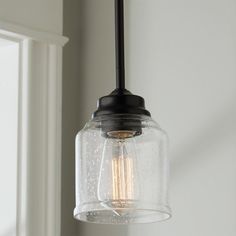 a glass light fixture hanging from a ceiling