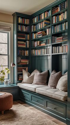 a living room filled with lots of books on green bookcases next to a window