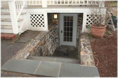 the front door is open and there are steps leading up to an entrance with a stone wall