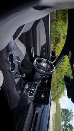 the interior of a vehicle with steering wheel controls and dash board in view from above