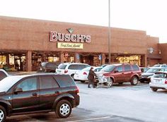 a bunch of cars are parked in front of a bushish's storefront