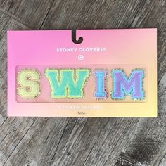 a sticker that says swim on it in front of a wooden background with the word swim