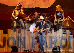 a group of people that are on stage with guitars