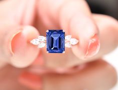 a close up of a person holding a ring with a blue and white stone in it