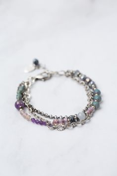 Experience the beauty and versatility of the Reflections Collection. Each piece is thoughtfully handcrafted using carefully chosen materials. This multistrand bracelet measures 7.5-8.5" and is completed an antique silver plated brass extender chain and lobster claw clasp. Elevate your style with Reflections. Antique Silver Plated Brass (lead and nickel free) Amethyst, Blue Lace Agate, Pearl 7.5-8.5", adjustable with antique silver plated brass lobster claw clasp We hand select our natural materi Adjustable Hand-wrapped Agate Bracelets, Vintage Silver Amethyst Bracelets, Silver Agate Hand-strung Beaded Bracelets, Elegant Hand-strung Amethyst Beaded Bracelets, Blue Lace Agate Bracelet, Multi Strand Bracelet, Blue Lace Agate, Lace Agate, Blue Lace