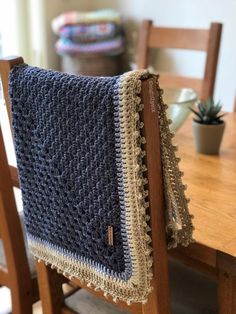 a blue and white blanket sitting on top of a wooden table next to a potted plant