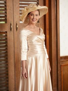 a woman in a dress and hat posing for the camera