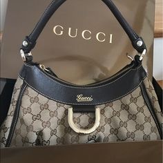 Authentic Gucci Hobo Bag W/ D Ring Gold. Gently Used. Minor Scuffs On Four Corners Shown In Pic. Other Than That, It's In Great Condition, Clean Inside, Has Zipper. Handle Is Still Great Shape. No Trades. I Don't Have The Dust Bag But Will Come In The Box That Came With It As Shown. Only Accepting Offers Within This Range. Posh Will Authenticate Items Over 500 For Free! Elegant Bags With Gold-tone Hardware And Monogram Canvas, Gucci Handheld Shoulder Bag For Formal Occasions, Gucci Formal Handheld Shoulder Bag, Designer Shoulder Bag With Gold-tone Hardware For Shopping, Formal Gucci Handheld Shoulder Bag, Designer Formal Bags In Monogram Canvas, Elegant Handheld Monogram Canvas Bag, Gucci Formal Shoulder Bag With Dust Bag, Formal Monogram Canvas Shoulder Bag With Branded Hardware