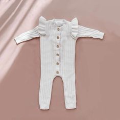 Discover pure adorableness with our Baby Girl Ruffle Knit Jumpsuit, an absolute must-have for your little fashionista! This charming one-piece is crafted with the utmost care, featuring delightful ruffle details that add a touch of sweetness to every wriggle and giggle. Whether it's playtime or a special occasion, our Ruffle Knit Jumpsuit is the perfect choice for capturing those precious moments in style with your little girl. Cold wash and hang dry Spring Ruffled Onesie For Loungewear, Spring Loungewear Onesie With Ruffles, Cream Fitted Bubble Romper With Ruffles, Fitted Cream Bubble Romper With Ruffles, White Cotton Onesie With Ruffles, Solid Cotton Bodysuit With Ruffles, White Long Sleeve Bubble Romper For Loungewear, White Ruffled Onesie For Playtime, White Ruffled Bubble Romper For Playtime