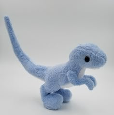 a blue stuffed toy dinosaur on a white background