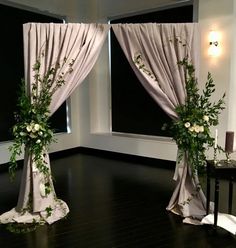 two white flowers are sitting on the windowsills in an empty room with black flooring