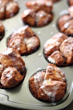 a muffin tin filled with cinnamon rolls covered in icing