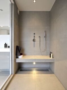 a bathroom with a sink, shower head and shelf in it's center area