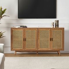 an entertainment center with wicker doors in front of a flat screen tv