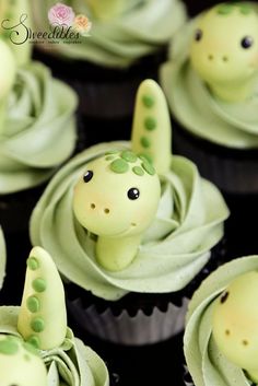 some cupcakes with green frosting decorated like animals