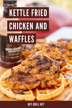 chicken and waffles on a wooden cutting board with ketchup in the background