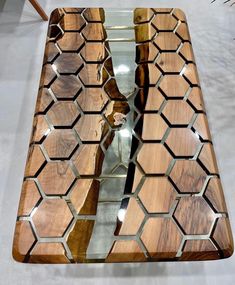 a wooden table with glass top and hexagonal pattern on the surface, reflecting light