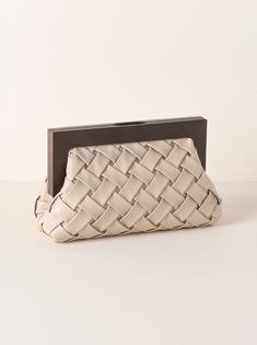 Carry your essentials in style with Shiraleah's Charlotte Frame Clutch. This handhel purse features a vegan leather woven texture and a wood top handle, adding a sophisticated edge to this chic silhouette. Measuring L 11" × W 4" × H 7.25", and equipped with a magnetic frame closure and inner slip pocket, the Charlotte Frame Clutch is the perfect addition to your favorite outfit. Pair with other items from Shiraleah to complete your look! Color: Ivory L 11" × W 4" × H 7.25" Woven Pu And Wood Magn Chic Clutch With Braided Handles For Everyday, Chic Everyday Clutch With Braided Handles, Chic Woven Leather Clutch For Everyday Use, Chic Everyday Woven Leather Clutch, Chic Textured Leather Rectangular Clutch, Beige Rectangular Clutch With Leather Handles, Chic Rectangular Textured Leather Clutch, Chic Natural Clutch For Formal Occasions, Chic Brown Woven Clutch