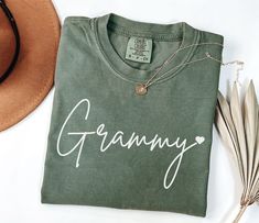 a green t - shirt with the word granny written on it next to a hat