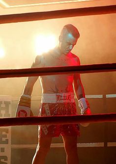 a man standing in the middle of a boxing ring