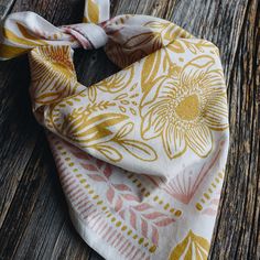 a yellow and white scarf on top of a wooden table