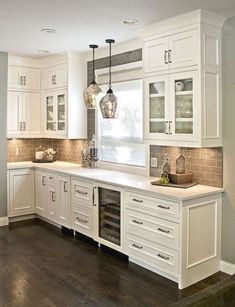 a kitchen with white cabinets and wooden floors