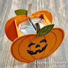 an orange pumpkin shaped box filled with candy