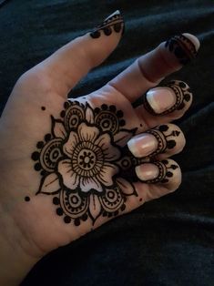 a woman's hand with henna tattoos on it