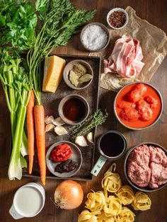 the ingredients for an italian pasta dish laid out on a wooden table