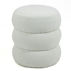 three white round cushions stacked on top of each other in front of a white background