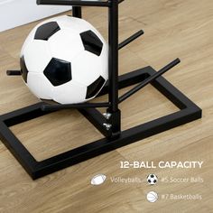 a soccer ball sitting on top of a wooden floor next to a black and white stand