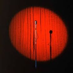 an image of two microphones in the middle of a dark room with red light