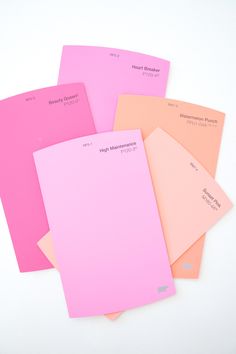 five different colors of paper stacked on top of each other, with one being pink and the other is orange